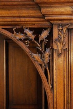 an ornate wooden shelf with leaves and acorns on the top, along with other wood paneling