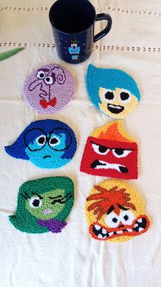 crocheted coasters with cartoon characters on them and a coffee cup in the middle