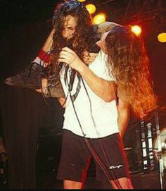 a man with long hair standing on stage