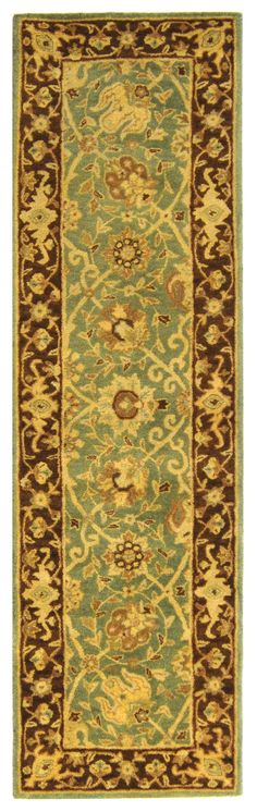 a green and brown rug with an ornate border