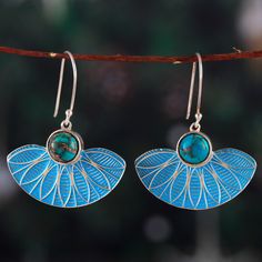 Let the enchanting and serene essence of the sky take over your style with Sapna Mehta's newest design. Crafted by local artisans, these sterling silver dangle earrings pay homage to the Indian region with classic fan-shaped pendants painted in blue, the color of intuition. As a luxurious touch, reconstituted turquoise jewels crown each piece, adding a refreshing accent. Wood Dangle Earrings, Indian Street, Blue Dangle Earrings, Sterling Silver Cat, Traditional Earrings, Street Market, Sterling Silver Brooch, Beaded Pendant Necklace, Silver Dangle Earrings