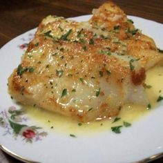 a white plate topped with fish covered in sauce