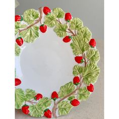 a plate with strawberries and leaves painted on it