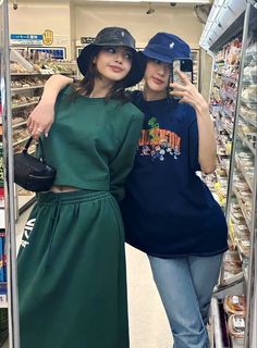 two women standing next to each other in front of a display case at a grocery store