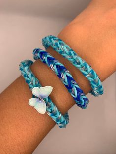 a woman's arm with three bracelets on it and a flower in the middle