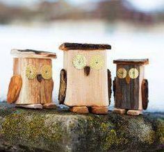 three small wooden owls sitting on top of a rock