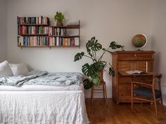 a bedroom with a bed, desk and bookshelf