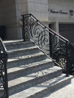 a wrought iron stair rail and handrail in front of a building