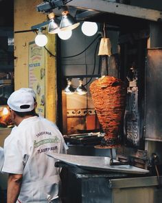 a man standing in front of a kitchen cooking food on top of a stove next to a frying pan