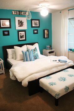 a bed room with a neatly made bed and pictures on the wall