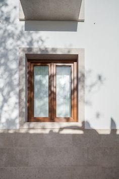 a cat is sitting on the ledge of a building next to a door and window