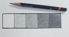 the pencil is next to four different shades of gray and white paper with orange writing on it