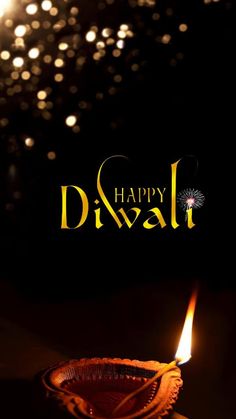 a lit diya with the words happy diwal written in gold on it and sparkles in the background