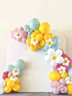 balloons are arranged in the shape of an arch with flowers on it, along with other decorations