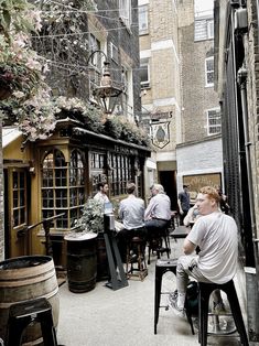 several people sitting at tables in an alleyway