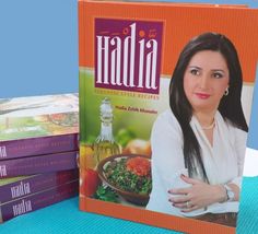 a stack of cookbooks sitting on top of a blue table next to a pool