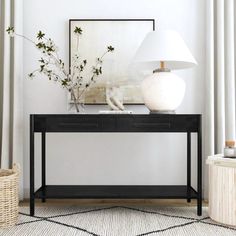 a white lamp sitting on top of a table next to a black and white rug