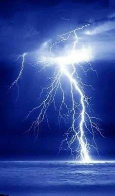 a lightning bolt is seen over the ocean