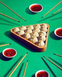 there are many small bowls with food in them and chopsticks on the table