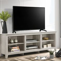 a flat screen tv sitting on top of a wooden entertainment center in a living room