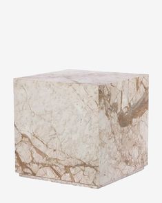 a white marble cube with brown veining on the top and bottom, sitting in front of a white background