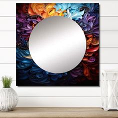 a round mirror sitting on top of a wooden table next to a vase and plant