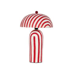 a red and white striped lamp sitting on top of a table