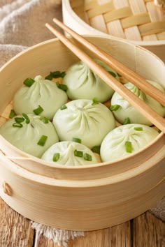 some dumplings are in a wooden bowl with chopsticks