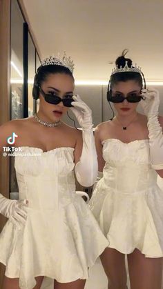 two women wearing white dresses and headphones