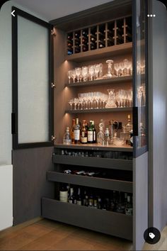 an open cabinet filled with lots of bottles and glasses