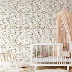 a baby's crib in front of a wallpapered background with trees