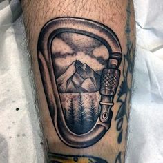 a man's leg with a tattoo on it and an image of mountains in the background