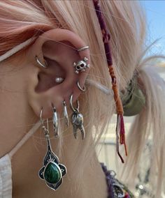 a close up of a person with ear piercings on their ears and wearing jewelry