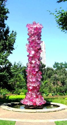 a large pink sculpture in the middle of a park