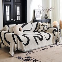 a black and white couch in a living room with pillows on it's back