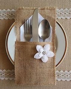 a place setting with silverware and napkins on a burlap table cloth