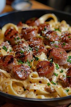 pasta with sausage and parmesan cheese in a skillet on a wooden table