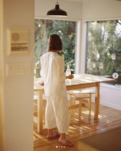 a woman standing in front of a dining room table