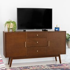 a flat screen tv sitting on top of a wooden cabinet