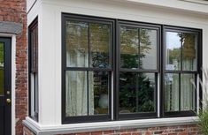 a brick house with black windows and white trim