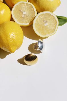 several lemons, one cut in half and the other sliced up with a spoon