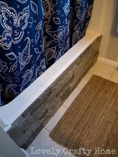 a bathroom with a blue shower curtain and rug