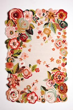 an area rug with flowers and leaves is shown on a white surface, in the shape of a square