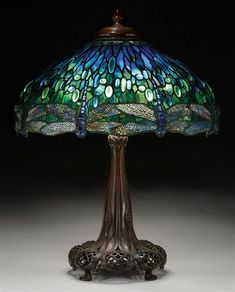 a lamp that is sitting on top of a table with a dragonfly design on it