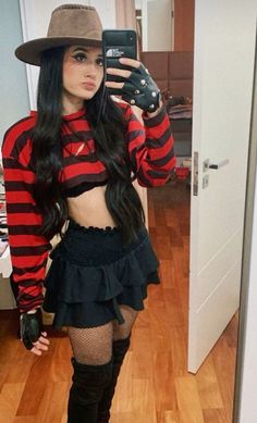 a woman in a red and black striped shirt is taking a selfie