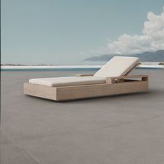 an outdoor chaise lounge with the ocean in the background