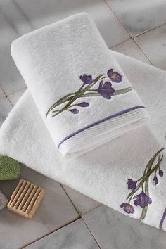 two white towels with purple flowers on them