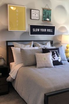 a bed room with a neatly made bed and some pictures on the wall above it