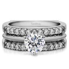 a white gold engagement ring set with two matching bands and a round diamond center stone