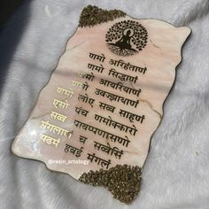 a stone plaque with an image of a tree and the words written in two languages